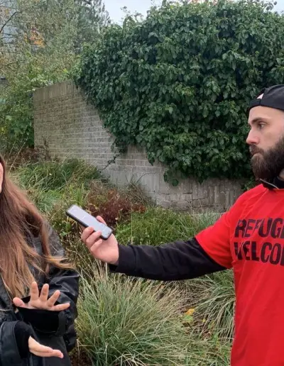 Man in a red shirt recording an interview at a Turning Point UK event.