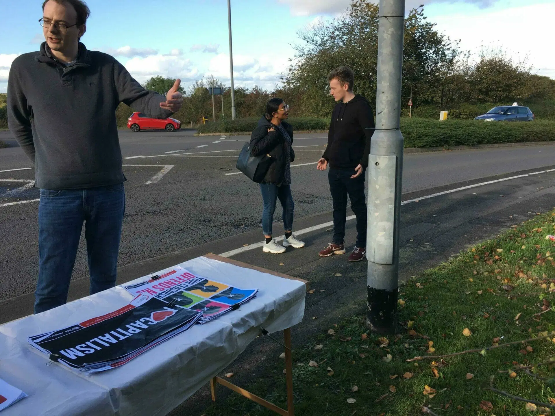 Three TPUK activists at an outreach table with campaign pamphlets on campus.